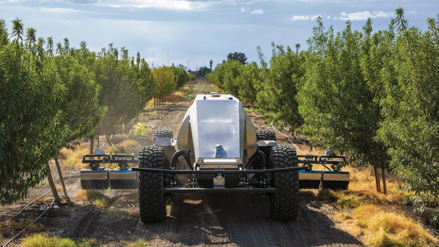 Pulverizador autónomo GUSS trabajando entre hileras de cultivo. La plataforma combina GPS, sensores LiDAR y software de navegación para desplazarse sin conductor incluso en ambientes donde la cobertura vegetal dificulta la recepción satelital. Imagen: John Deere/GUSS Automation.